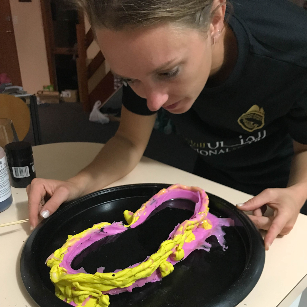 IDA Sports co-founder Laura Youngson leans over the mold of a women's soccer shoe in her kitchen.